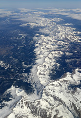 Aerial view of beautiful snow covered mountains, clouds and alpine landscape of the Rocky Mountains, Colorado