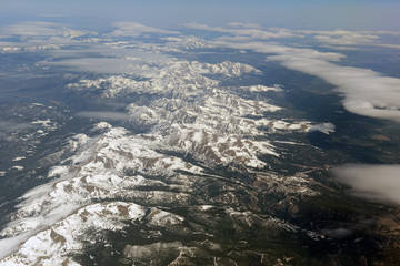 Aerial view of beautiful snow covered mountains, clouds and alpine landscape of the Rocky Mountains, Colorado