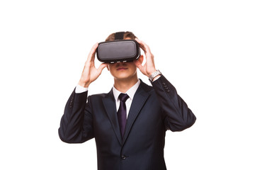 Young handsome businessman in black suit wearing virtual reality goggles., isolated on white background