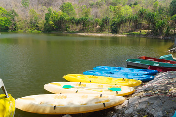 Colorful kayaks near a river or lake for outdoor activity.