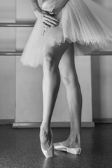 Ballerina in pointes and a pack warms up before the dance lesson. Long slender female feet. Classical ballet. Prima ballerina.
