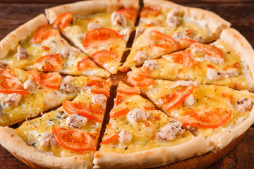 Appetizing italian hot pizza cut on slices served on wooden platter. Traditional cuisine, fast food, close up.
