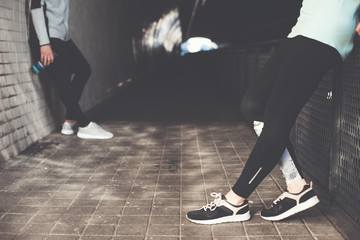 Fototapeta premium Couple of athletes standing in the tunnel. Man and woman resting before street workout