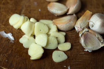 Garlic and garlic press on rustic wooden wooden background