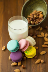 Tasty macaroons and cup of milk with almond on wooden background Selective focus.
