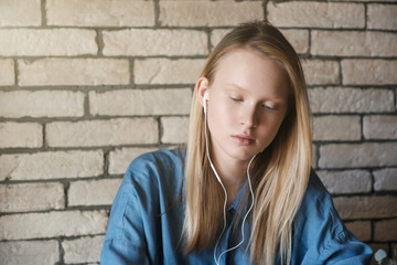Portrait of young blonde girl with headphones