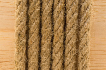 Twisted brown rope on the background of the board