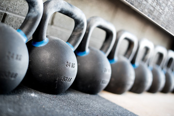Naklejka na ściany i meble Row of kettlebell or girya weights in a gym
