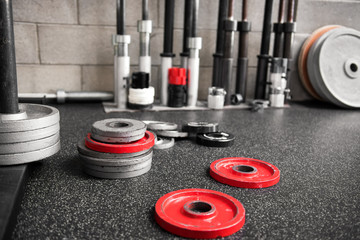 Assorted weights scattered on the floor of a gym