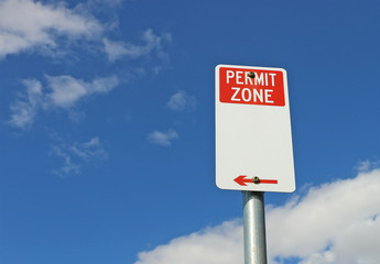 red and white Permit Zone sign in a bright blue sky