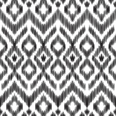 Vector illustration of the black and white colored ikat ornamental seamless pattern. Chevron design. Scribble textured effect. Ethnic style. - 144681712