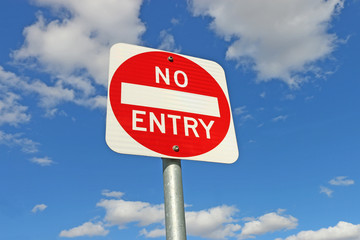 red and white No Entry sign in a blue sky