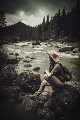 Beautiful woman hiker near wild mountain river.