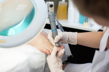 Professional pedicure master making pedicure in salon