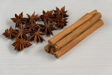 Cinnamon sticks and star anise on white wooden background.