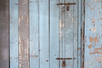 Old and faded light blue wood board wall or door texture background.
