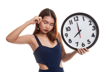 Sleepy young Asian woman with a clock in the morning.