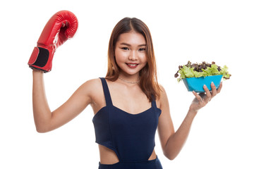 Young Asian woman with boxing glove and salad.