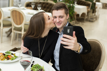Beautiful couple taking selfie photo in a restaurant
