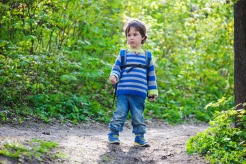 A child walks through the woods.