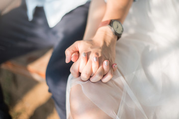 Closeup of woman and man holding hands together