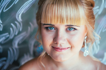 portrait of young beautiful happy bride near the window