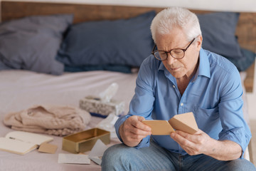Good looking aged man reading a note