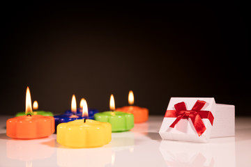 brennende bunte kerzen mit geschenk