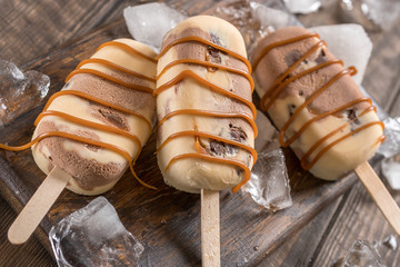 Homemade caramel chocolate popsicles with candy