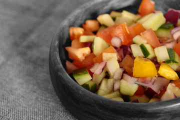 Selective colour image of a salad salsa in a wooden bowl