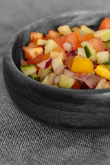 Selective colour image of a salad salsa in a wooden bowl