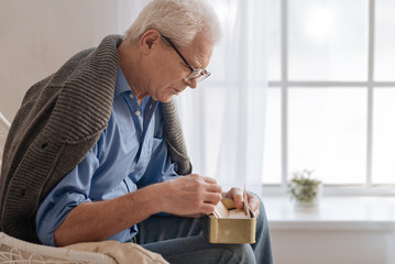 Depressed aged man sitting near the window