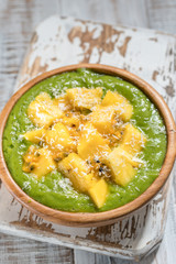 Green smoothie bowl with fruits and kale
