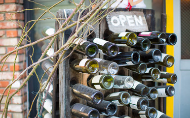 Wine Bottles on a Rack with an "Open" Sign in front of a business