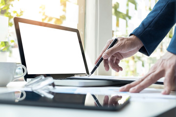 Business man working at office with laptop, tablet and graph data documents on his desk