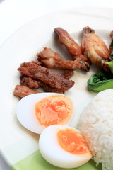 stir fried vegetables, Hard-boiled egg, Fried pork and Fried chicken wings with thai jasmine rice on dish. Thai food.