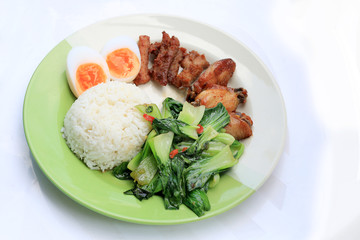 stir fried vegetables, Hard-boiled egg, Fried pork and Fried chicken wings with thai jasmine rice on dish. Thai food.