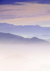 Mountain layer in morning sun ray and winter fog