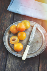 Yellow mirabelle plums in rustic metal dish