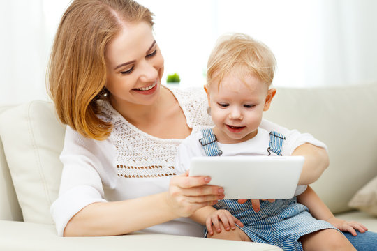 Mother and baby son with a tablet computer at home