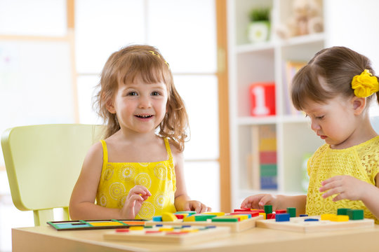 Children kids play with educational toys, arranging and sorting colors and shapes. Learning via experience conception.