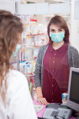 Pharmacist and her client in front of the desk. Healthcare business