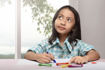 Cute asian little child drawing with colorful crayon