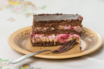 Fruit cake with chocolate served on the plate with fork on it