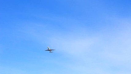White passenger plane is taking off in a blue sky. Full HD footage clip.