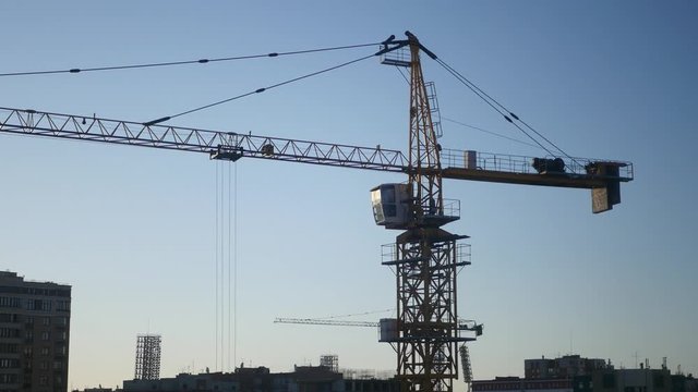 Construction crane in the blue sky and sunset in the sun. 4K
