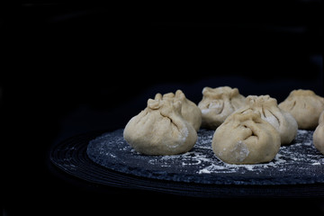 Homemade organic raw steamed Chinese bun on black slate stone plate 