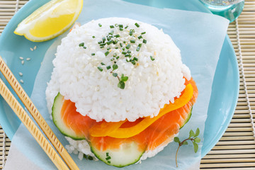 Fresh fish burger from rice instead of bread with fish and vegetables. Japanese cuisine in the American manner.