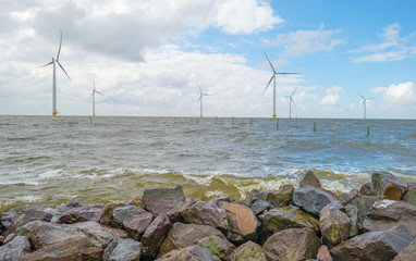 Wind turbines along a dike in spring