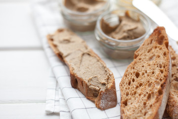 Bread with veal and rabbit pate with butter on a textile background